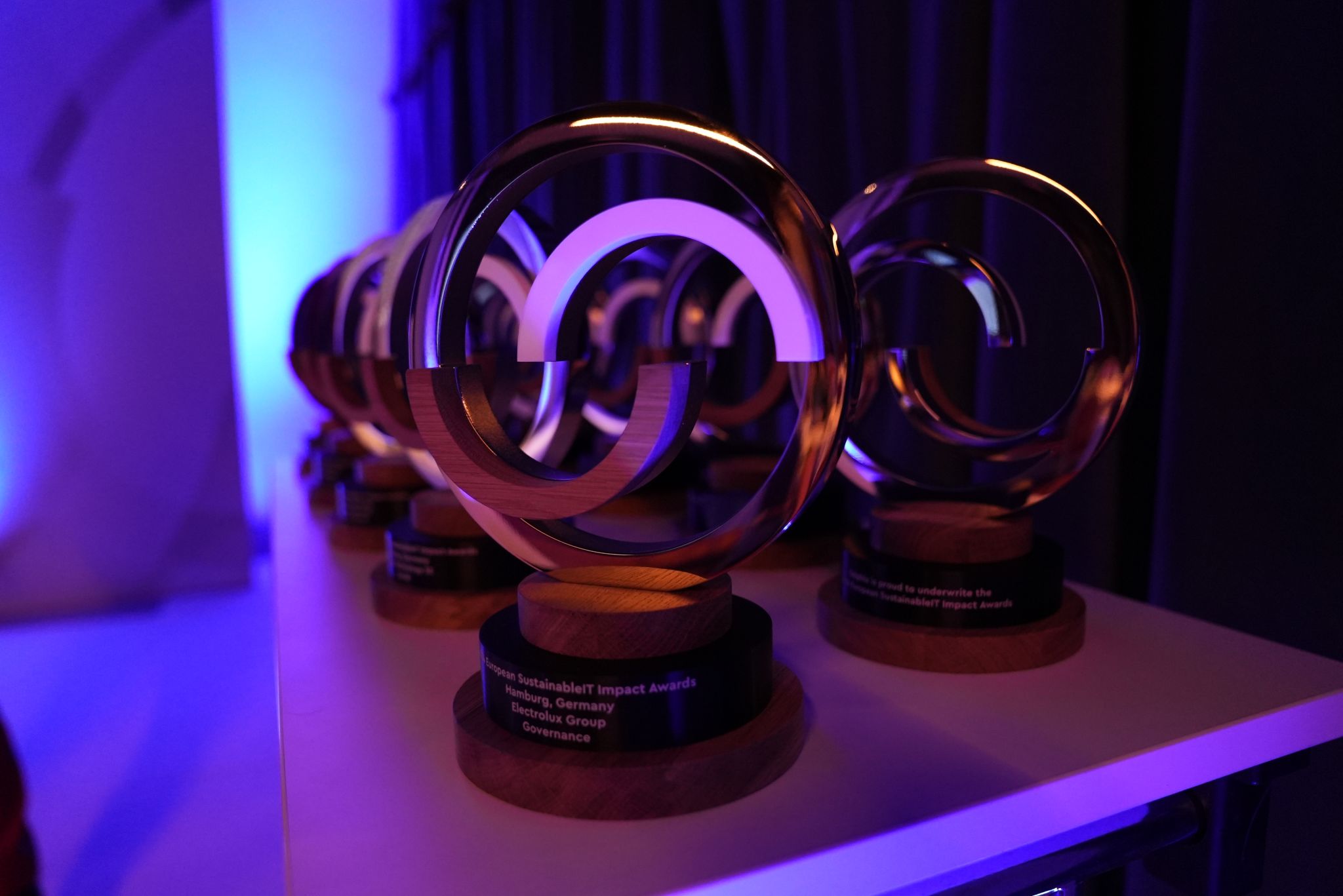 A row of SustainableIT IMPACT Award trophies lit at the ceremony